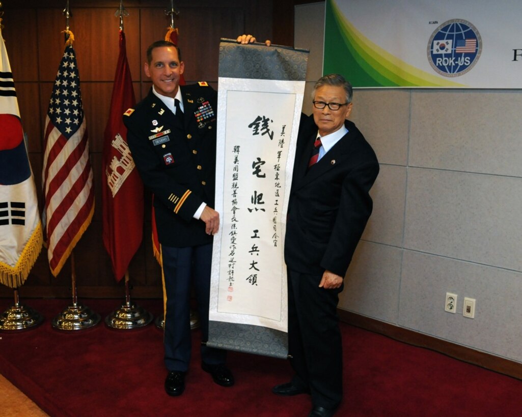 SEOUL, Korea — Suh Jin-Sup (right), Chairman of the ROK-U.S. Alliance Friendship Association, presents Col. Donald E. Degidio, Jr., Commander of the U.S. Army Corps of Engineers, Far East District, a scroll with “Jeon Taek-Hee,” Degidio’s new Korean name written in Hanja, traditional Korean characters, May 10 at the Korea Ministry of National Defense.  