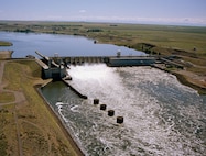 Located at the upstream end of Lake Wallula,
the dam is 2,822 feet long with an effective height of 100 feet. The dam is a concrete gravity type, with an earthfill embankment section at the north abutment. It includes a navigation lock with clear dimensions of 86 by 675 feet; and a ten-bay spillway that is 590 feet long, with ten 50-foot tainter gates.