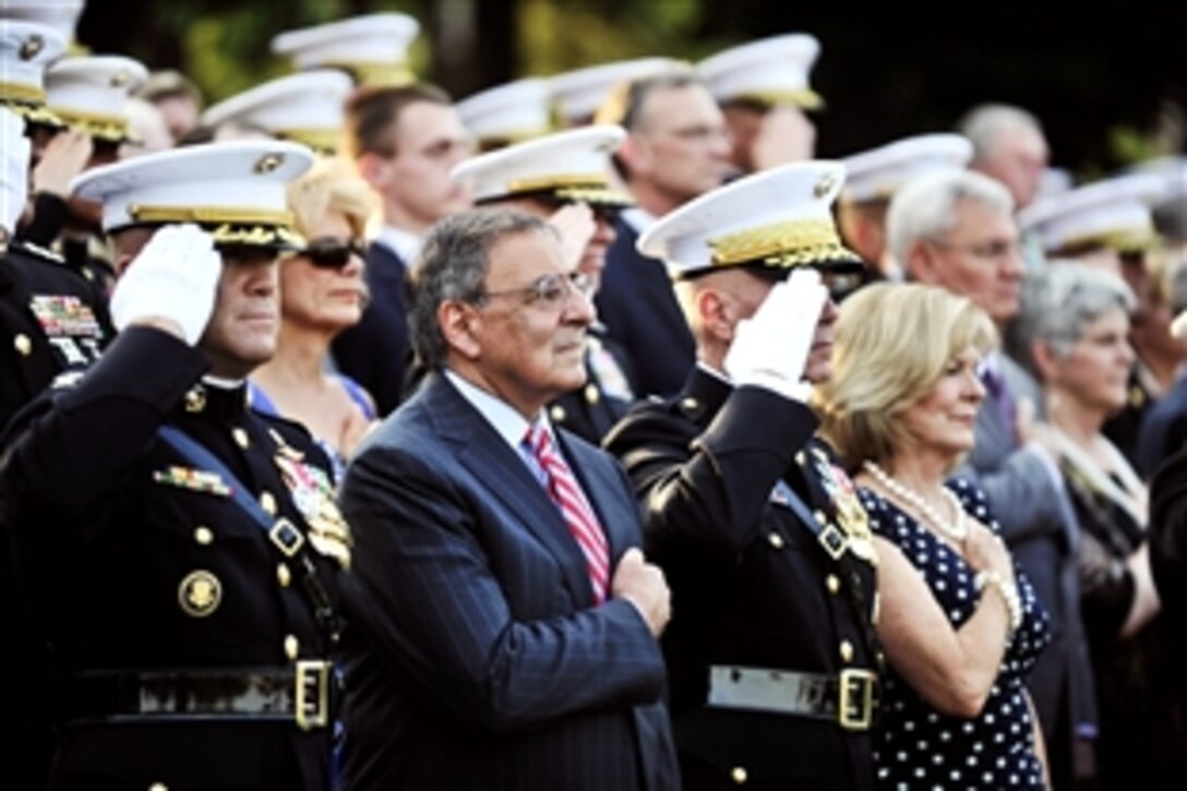 Defense Secretary Leon E. Panetta lays his hand over his heart rendering honors as colors are placed during the observance of the Marine Corps Aviation Centennial in Arlington, Va., May 16, 2012.
