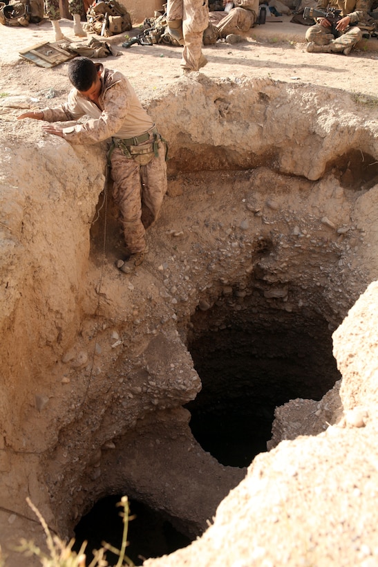 Lance Cpl. Anthony Quintanilla makes his way into a well in an abandoned compound during Operation Sangin United Horizons here, May 17, 2012. Quintanilla, a native of Los Angeles, found narcotics, weapons, and components to construct an improvised explosive device hidden inside the well.