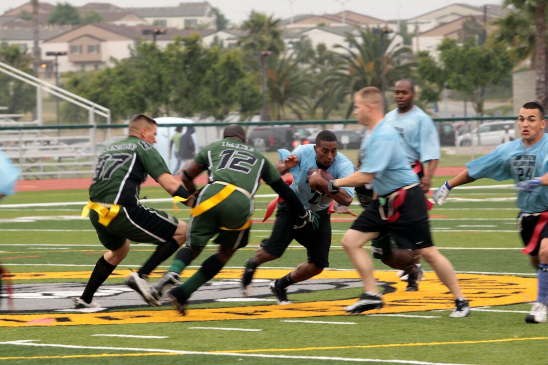 Freddy Richardson charges through the defense to gain a few yards during the 2012 Flag Football Championship League on Camp Pendleton, May 17. The Combat Logistics Regiment 17 Desk Jockeys overcame their opponents, the Assault Amphibious School Battalion Gators, with a score of 26 to eight. Richardson is the quarterback for the Desk Jockeys.