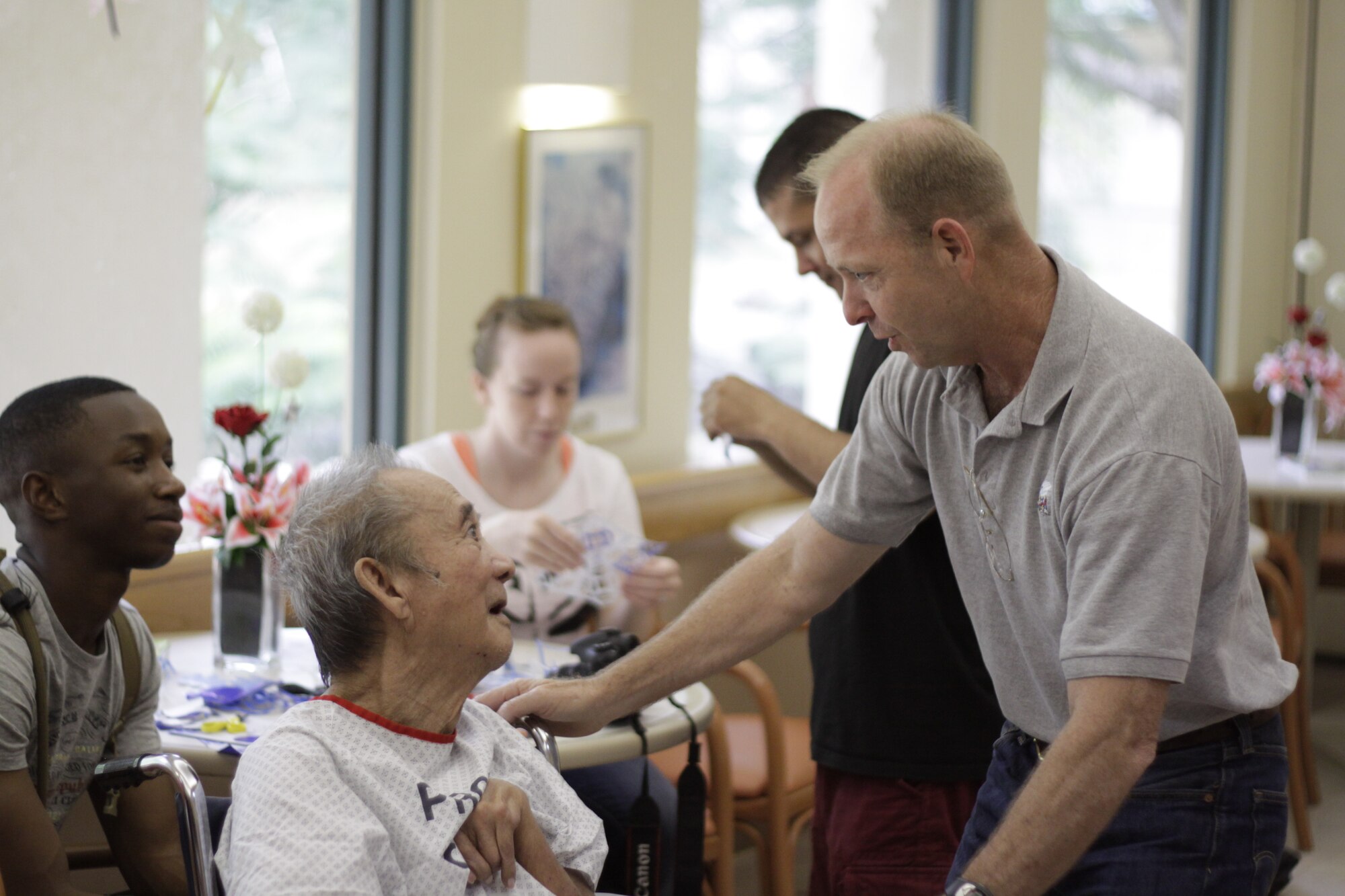 Cmdr. Dean L. Hoelz, Marine Aircraft Group 12 chaplain, talks with a patient at the Guam Memorial Hospital here May 18, 2012. Volunteers spent the afternoon with hospital patients during a community relations project as part of Exercise Geiger Fury 2012.