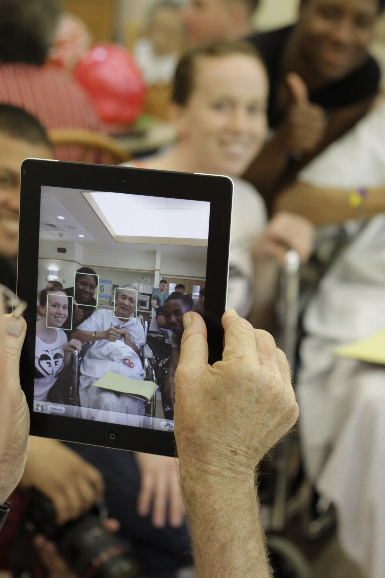 Cmdr. Dean L. Hoelz, Marine Aircraft Group 12 chaplain, takes a picture of a patient and volunteers at the Guam Memorial Hospital here May 18. The Marines and sailors were in Guam in support of Exercise Geiger Fury.