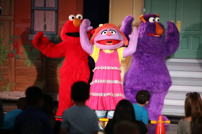 Elmo and his friends console Katie, a new member to the Sesame Street cast, during a USO performance of Sesame Street Live aboard Marine Corps Air Station New River, April 28. Katie, a military child, was distraught over moving to a new town before the Sesame Street cast showed her and the audience how she can cope with her new life.