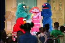 Elmo and his friends console Katie, a new member to the Sesame Street cast, during a USO performance of Sesame Street Live aboard Marine Corps Air Station New River, April 28. Katie, a military child, was distraught over moving to a new town before the Sesame Street cast showed her and the audience how she can cope with her new life. 