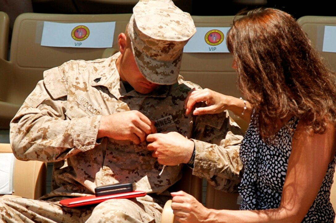Sgt. Clifford Wooldridge, combat weapons instructor, Marine Corps Security Forces Regiment, Chesapeake, Va., shows his mother the Navy Cross Medal May 18 at Lance Cpl Torrey L. Gray Field. He earned the medal for combat actions in Helmand province, Afghanistan, while attached to 3rd Battalion, 7th Marine Regiment, in 2010.
