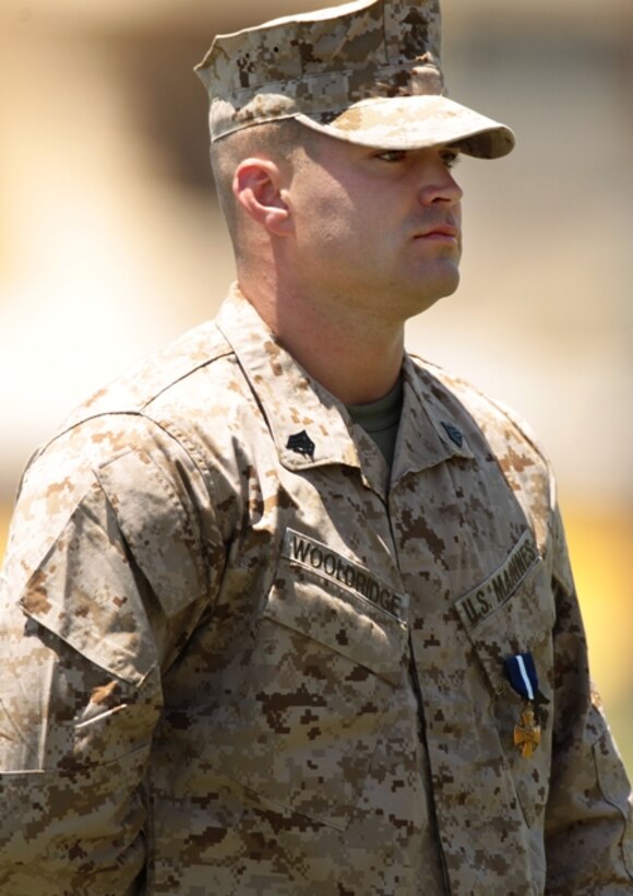 Sgt. Clifford Wooldridge, combat weapons instructor, Marine Corps Security Forces Regiment, Chesapeake, Va., stands at attention after receiving the Navy Cross Medal May 18 at Lance Cpl Torrey L. Gray Field. He earned the medal for combat actions in Helmand province, Afghanistan, while attached to 3rd Battalion, 7th Marine Regiment, in 2010.