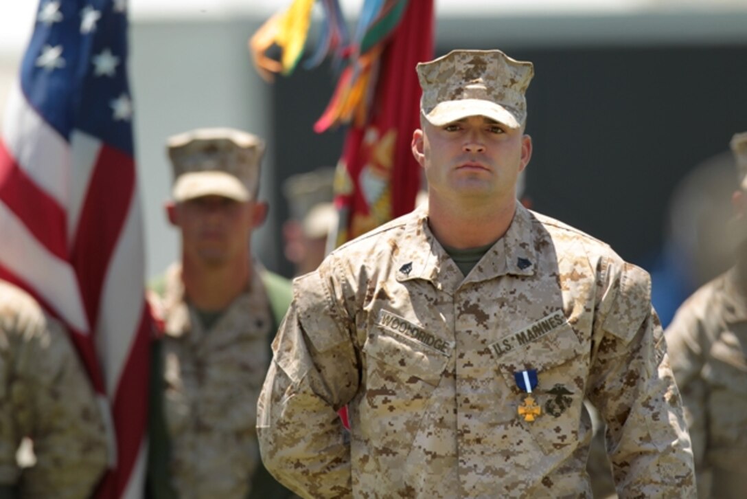 Sgt. Clifford Wooldridge, combat weapons instructor, Marine Corps Security Forces Regiment, Chesapeake, Va., stands at parade rest after receiving the Navy Cross Medal May 18 at Lance Cpl. Torrey L. Gray Field. He earned the medal for combat actions in Helmand province, Afghanistan, while attached to 3rd Battalion, 7th Marine Regiment, in 2010.