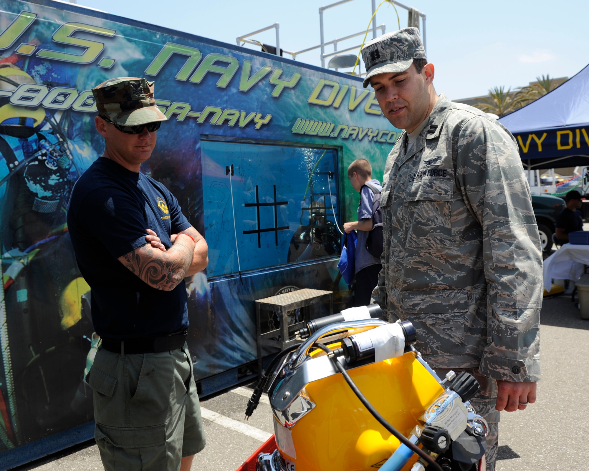 TORRANCE, Calif. --Capt. Michael May, a 30th Operations Group deputy chief of standardization and evaluation, learns about Navy diving equipment during the 53rd Annual Armed Forces Day here Friday, May 18, 2012. Military displays varied from rockets to tanks and were open for the public. (U.S. Air Force photo/Staff Sgt. Levi Riendeau) 

  