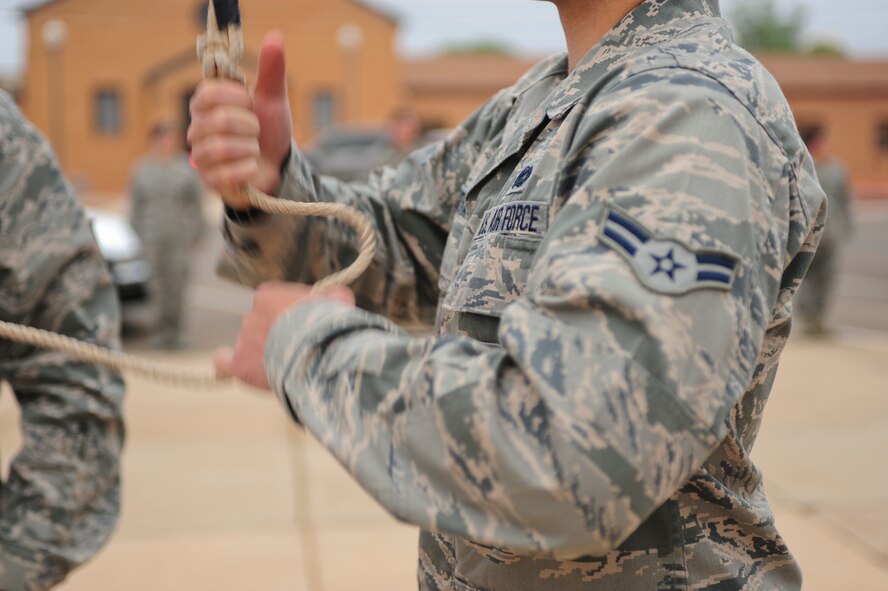 U.S. Air Force Airman 1st Class Kevin Plotka, 27th Special Operations Security Forces Squadron, pulls the rope to raise the flag during the reveille ceremony in honor of National Police Week at Cannon Air Force Base, N.M., May 14, 2012. National Police Week is May 13–19, 2012. (U.S. Air Force photo by Airman 1st Class Eboni Reece)