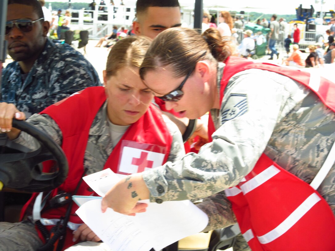 Master Sgt. Erica Jasper, NCOIC of Emergent Care and chief of the Golf Cart Team, gives directions to Senior Airman Jessica Seaborn, medical technician, Airman 1st Class Maiky Rodriguez, medical technician and Hospital Corpsman 1st Class Obi Nwagwu during the Joint Service Open House. The team is prepared to provide emergency care when they are needed. This year's Joint Service Open House celebrates the Centennial of Marine Corps Aviation. JSOH affords the public an opportunity to meet the men and women of the Armed Forces while viewing over 100 static displays and 19 aerial demonstration teams. (U.S. Air Force Photo by Melanie Moore)