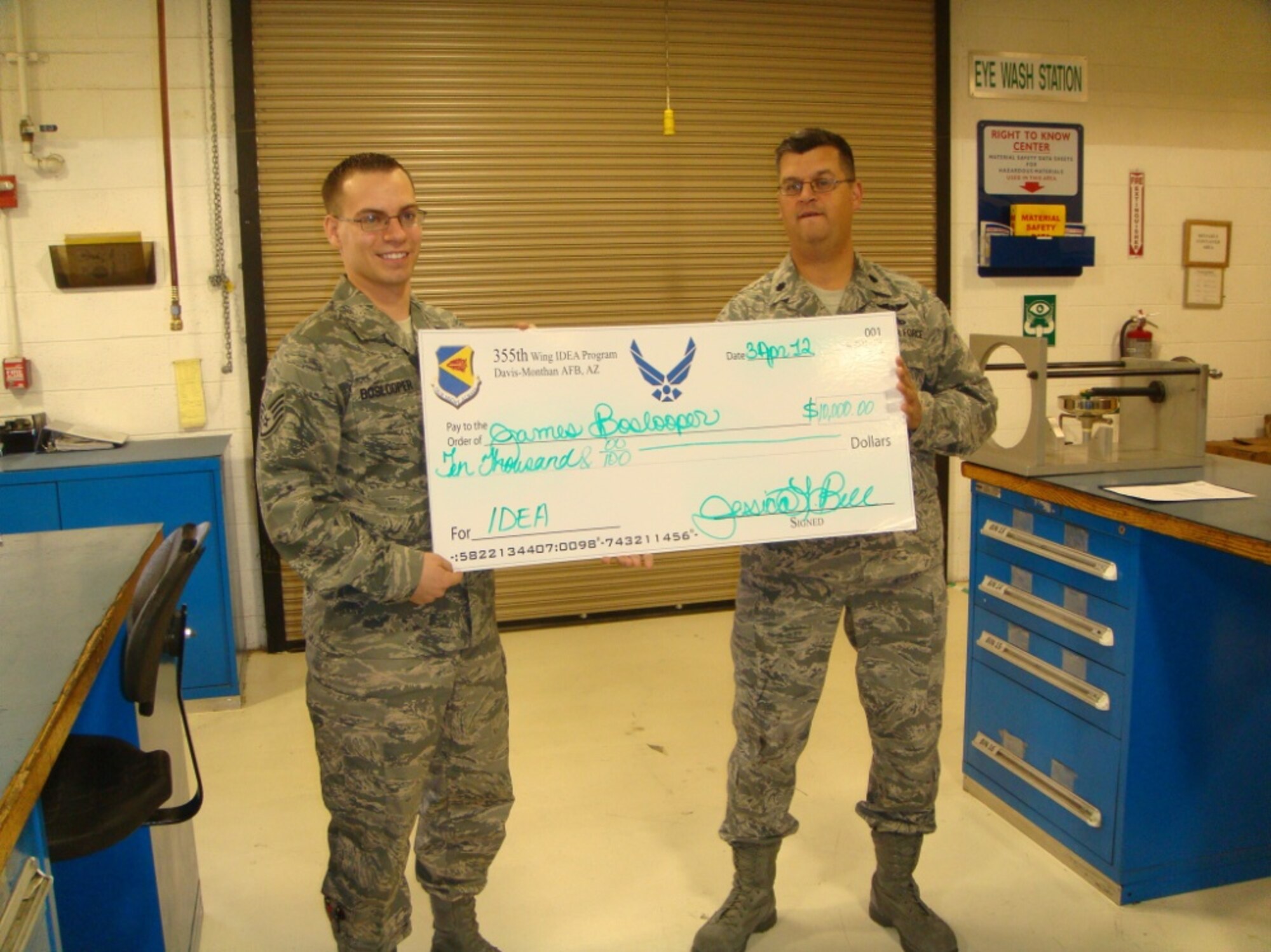 Lt. Col. Steven Haynes, 355th Component Maintenance Squadron commander, presents Staff Sgt. James Boslooper, 355th CMS hydraulic systems craftsman, with a $10,000 check from the D-M IDEA program. (Courtesy photo)