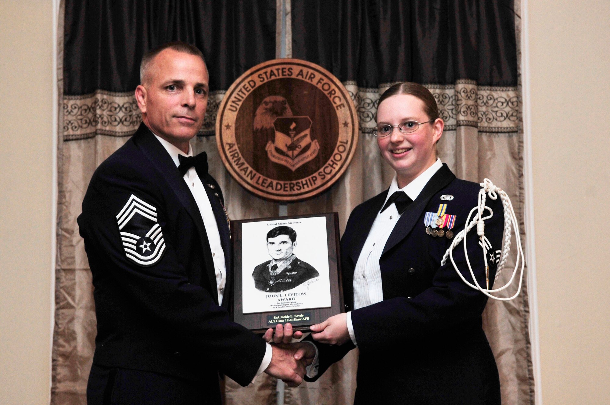 U.S. Air Force Senior Airman Jackie Sevdy, United States Air Forces Central Command, receives the John Levitow award at her Airman Leadership School gradutation, Shaw Air Force Base, S.C., May 17, 2012. The Levitow award is the highest award in enlisted professional military education. Sevdy received this award for having the highest average of instructor and student points during the course and portraying excellence in all she did.(U.S. Air Force photo by Airman Nicole Sikorski/Released)