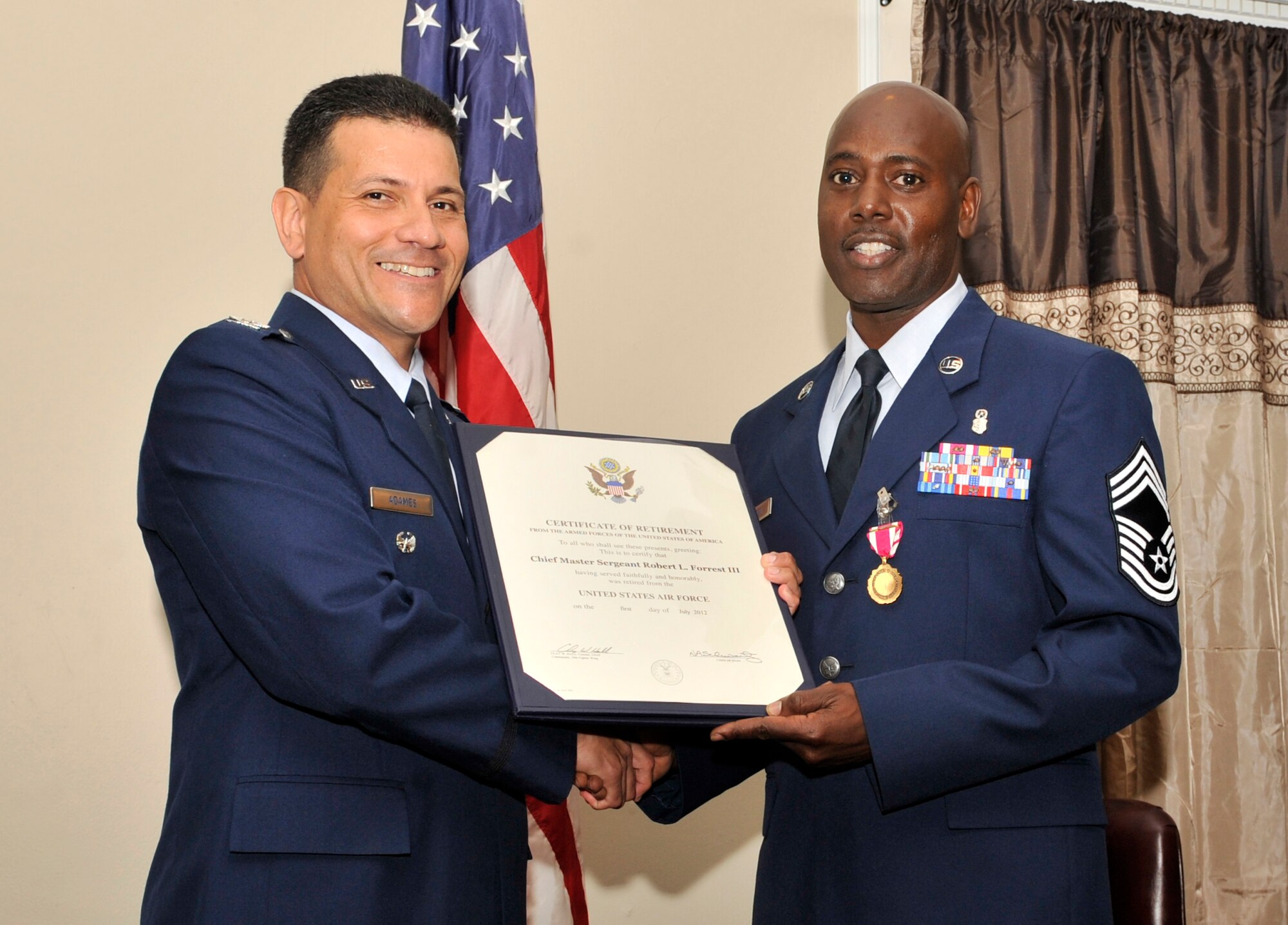 U.S. Air Force Col. Michael Adames, chief future strategy division, joint task forces and national capitol region, presents Chief Master Sgt. Robert Forrest, 20th Medical Group superintendent, his Certificate of Retirement from the Armed Forces of the United States of America at Carolina Skies Club, Shaw Air Base, S.C, May 18, 2012. Every retiree at the end of their service receives a Certificate of Retirement from the Armed Forces of the United States of America, thanking them for their faithful and honorable service to their country. (U.S. Air Force photo by Senior Airman Tabatha McCarthy/released)