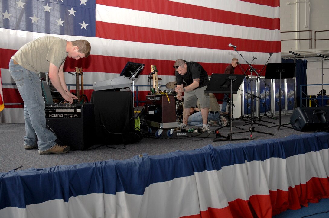 Members of the U.S. Air Force Heartland of America Band’s pop rock ensemble Raptor set up to perform music for the 70th Anniversary Kick-Off event at the Pride Hangar at Ellsworth Air Force Base, S.D., May 18, 2012. The Kick Off Celebration will feature activities for families beginning at 4:30 p.m. including the band performance, food, bouncing castles and other activities for children. (U.S. Air Force Photo by Airman 1st Class Anania Tekurio/Released)