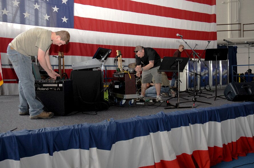 Members of the U.S. Air Force Heartland of America Band’s pop rock ensemble Raptor set up to perform music for the 70th Anniversary Kick-Off event at the Pride Hangar at Ellsworth Air Force Base, S.D., May 18, 2012. The Kick Off Celebration will feature activities for families beginning at 4:30 p.m. including the band performance, food, bouncing castles and other activities for children. (U.S. Air Force Photo by Airman 1st Class Anania Tekurio/Released)