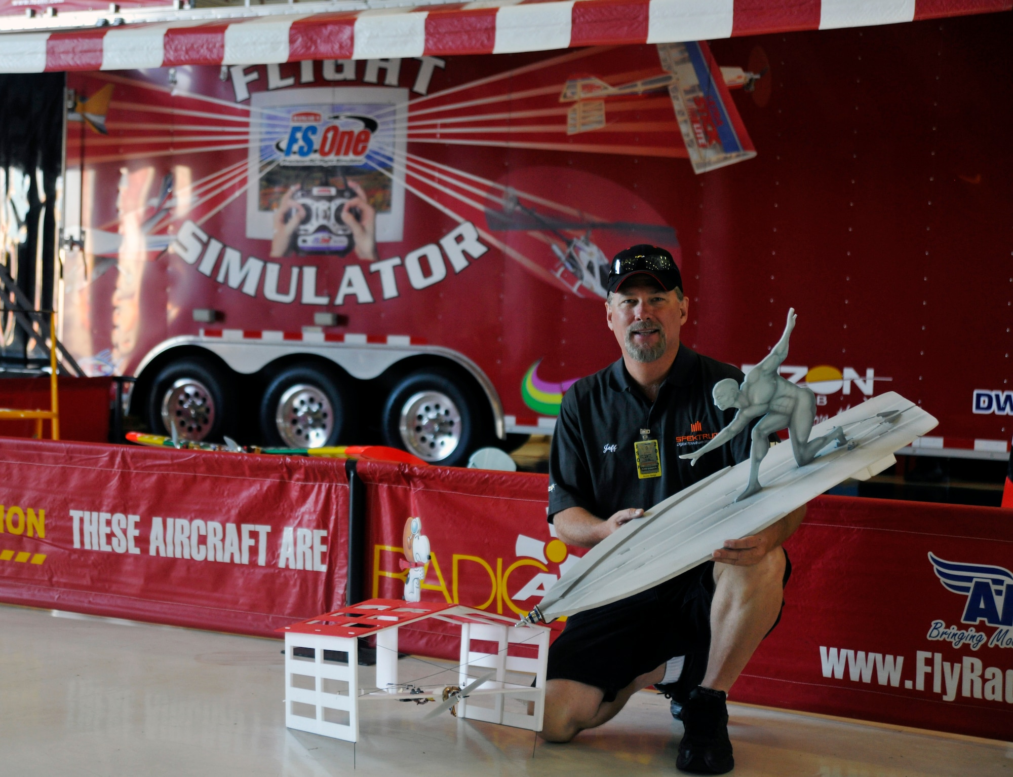 Michael Farlow, a Radio Active Airshows (RAA) employee and radio-controlled aircraft enthusiast, showcases two of RAA’s electric, foam-model novelty-act aircraft inside Hangar 3 on the Joint Base Andrews flightline May 18. This year's Joint Service Open House celebrates the Centennial of Marine Corps Aviation.  JSOH affords the public an opportunity to meet the men and women of the Armed Forces while seeing over 100 static displays and 19 aerial demonstration teams May 18-20 at Joint Base Andrews, Md. (U.S. Air Force photo/Senior Airman Lindsey A. Porter)