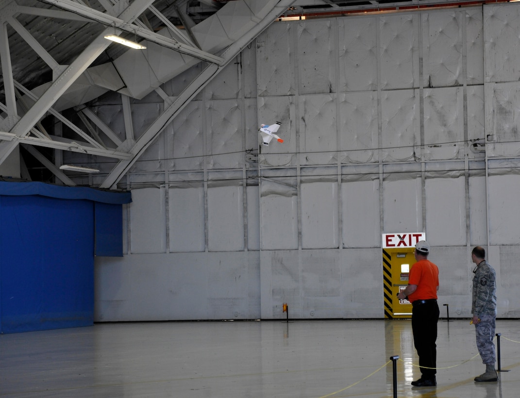 Looking on in awe, a patron to the 2012 Joint Service Open House and Air Show watches closely as a Radio Active Airshow employee showcases the flying capabilities of one of his electric, foam-model radio-controlled aircraft inside Hangar 3 of the Joint Base Andrews flightline May 18. This year's JSOH celebrates the Centennial of Marine Corps Aviation.  JSOH affords the public an opportunity to meet the men and women of the Armed Forces while seeing over 100 static displays and 19 aerial demonstration teams May 18-20 at Joint Base Andrews, Md. (U.S. Air Force photo/Senior Airman Lindsey A. Porter)