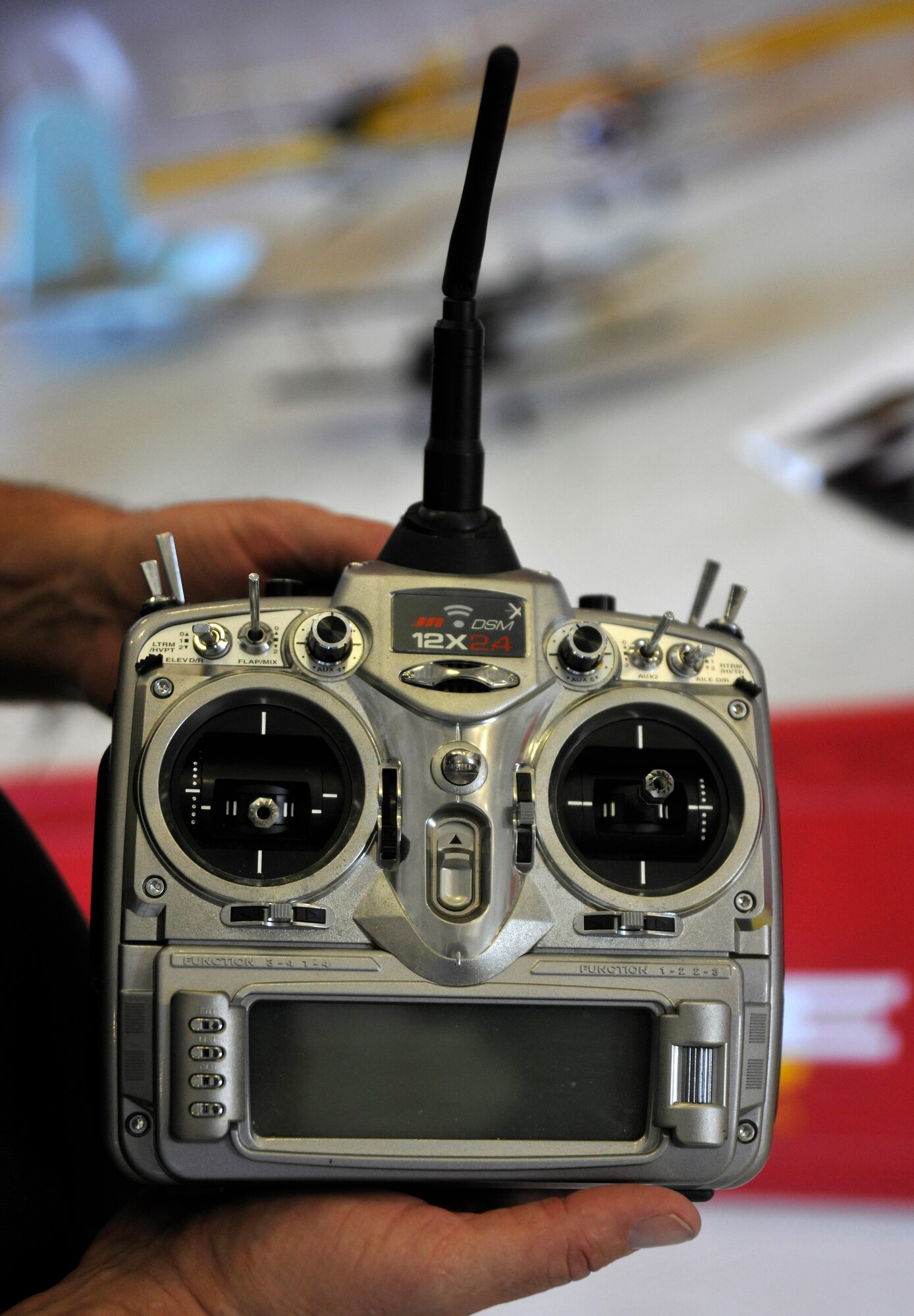 A member of Radio Active Aishows aerial demonstration team showcases a remote for his radio-controlled foam aircraft May 18. Remotes such as these are able to store flying information for more than five radio-controlled aircraft at one time. Patrons to the 2012 Joint Service Open House and Air Show are encouraged to stop by Hangar 3 on the Joint Base Andrews flightline and view radio-controlled aircraft displays controlled by remotes such as these. This year's JSOH celebrates the Centennial of Marine Corps Aviation.  JSOH affords the public an opportunity to meet the men and women of the Armed Forces while seeing over 100 static displays and 19 aerial demonstration teams May 18-20 at Joint Base Andrews, Md. (U.S. Air Force photo/Senior Airman Lindsey A. Porter)