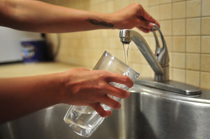 A U.S. Air Force service member pours herself a glass of tap water from a break room at Cannon Air Force Base, N.M., May 10, 2012. The local areas have a higher than naturally occurring fluoride level in their water systems which raises concerns of fluorosis, a condition that can cause permanent staining and pitting or mottling of the teeth. (U.S. Air Force photo by Airman 1st Class Alexxis Pons Abascal)  