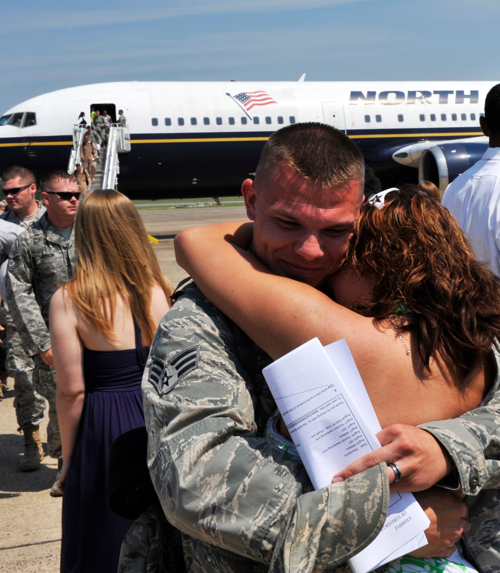 Senior Airman Daniel Abbott, a 19th Aircraft Maintenance Squadron engines technician, embraces his wife, Carolyn, on the flight line May 18, 2012, at Little Rock Air Force Base, Ark. Abbott returned with more than 100 of his peers from a deployment supporting combat operations in Southwest Asia. (U.S. Air Force photo by Airman 1st Class Rusty Frank)