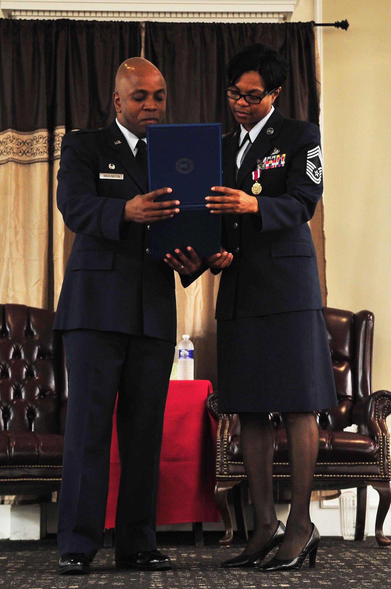 U.S. Air Force Lt. Col. Dalian Washington, 20th Force Support Squadron commander, and Chief Master Sgt. Perita Cook, 20th Force Support Squadron superintendent, read a certificate of appreciation for serving in the Air Force during Cook’s retirement ceremony, Shaw Air Force Base, S.C. May 18, 2012. Retirees are presented with awards to show that their work and time in the military was appreciated and memorable. (U.S. Air Force photo by Airman 1st Class Ashley L. Gardner/ Released)