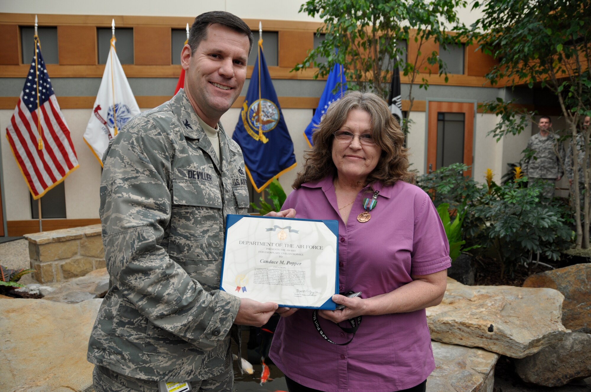 Col. John M. Devillier, Air Force Mortuary Affairs Operations commander, presents Candace Popper, AFMAO resource manager, with The Award for Exemplary Civilian Service May 17, 2012 at a commander's call at the Charles C. Carson Center for Mortuary Affairs, Dover Air Force Base, Del. (U.S. Air Force photo/ Staff Sgt. James W. Jackson) 