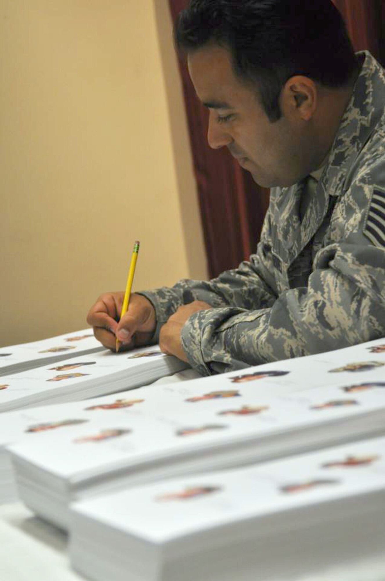Tech. Sgt. Robert Gutierrez, Special Tactics Training Squadron instructor, signed hundreds of Gathering of Eagles lithographs at Hurlburt Field Fla., May 17. Gutierrez, a recipient of the Air Force Cross. is the only active duty, enlisted Airman to be part of annual program that promotes air power lessons through first-hand experiences. He will join other legends such as prisoners of war and a Tuskegee Airman in June to share his story of resiliency at Maxwell Air Force Base's Air Command and Staff College.  (U. S. Air Force photo by Ashley M. Wright) 