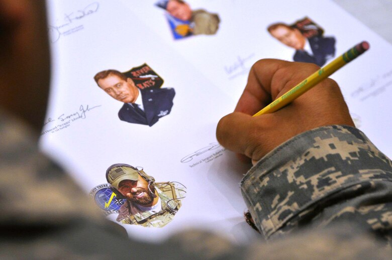 Tech. Sgt. Robert Gutierrez, Special Tactics Training Squadron instructor, signed hundreds of Gathering of Eagles lithographs at Hurlburt Field Fla., May 17. Gutierrez, a recipient of the Air Force Cross. is the only active duty, enlisted Airman to be part of annual program that promotes air power lessons through first-hand experiences. He will join other legends such as prisoners of war and a Tuskegee Airman in June to share his story of resiliency at Maxwell Air Force Base's Air Command and Staff College.  (U. S. Air Force photo by Ashley M. Wright) 