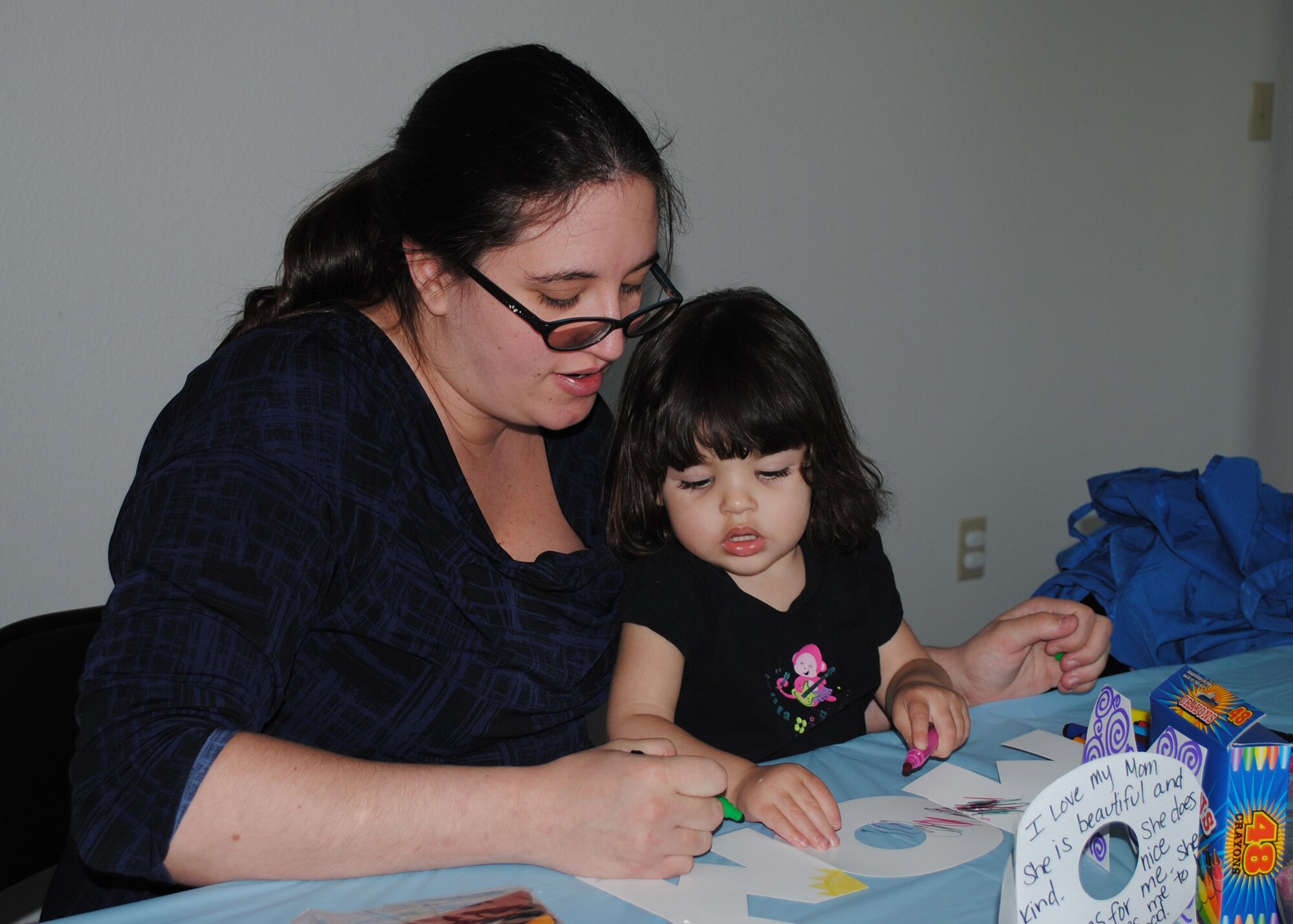 Tamara Ceballos and her daughter Teresa, 2, color in a "mom" stencil at a Mother's Day craft event May 10 at the Lifeworks House. Balfour Beatty, Malmstrom's housing contractor, sponsored the event as part of a Lifeworks initiative. Complete with cookies, drinks, music and fingerpaint, children and their mothers had an oporunity to get creative. (U.S. Air Force photo/Airman 1st Class Katrina Heikkinen)