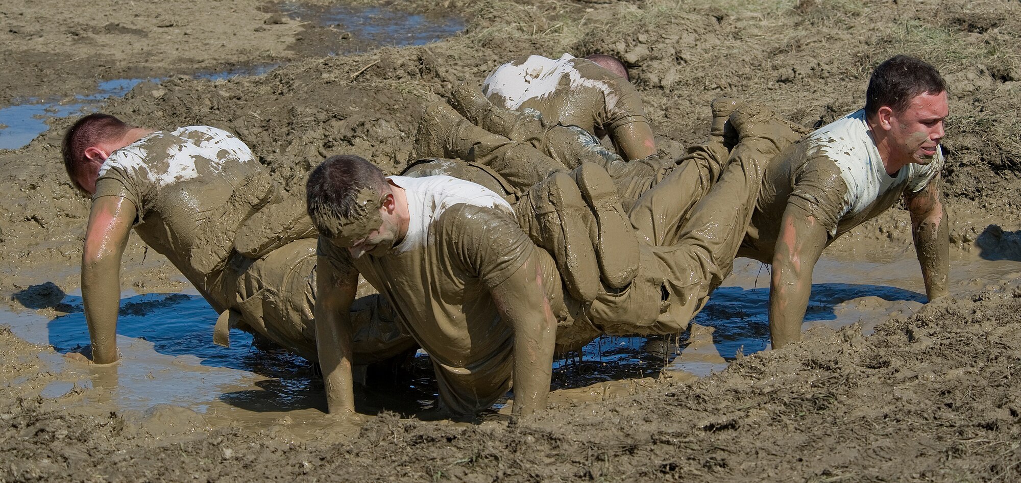 Members of Team 35 push themselves to their limit at the team pain station. Clockwise from left are, Airman 1st Class Alex Callahan, 741st MSFS security escort team member; Airman 1st Class Kyle Klusacek, 741st MSFS member; Airman 1st Class James St. John, 741st MSFS security escort team member; and Senior Airman Michael Gessner, 741st MSFS security escort team leader. Their team received the Team Pain Award for successfully completing the highest score with 85 push-ups and 68 tire flips. (U.S. Air Force photo/Beau Wade)