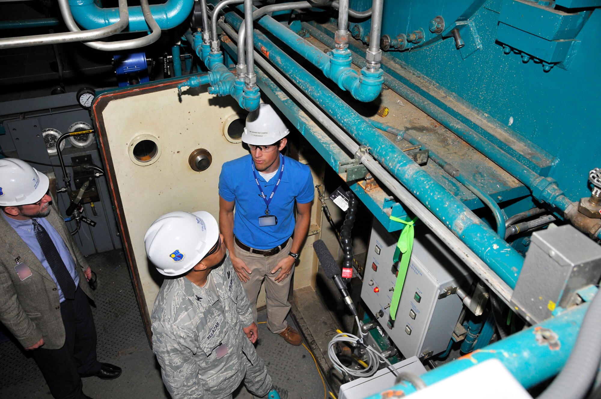 Dr. Davy Belk, AFFTC’s executive director at Edwards AFB and Col. Geoffrey Ellazar, Jr, AFFTC director of contracting, listen as Tyler Neale, a Propulsion Wind Tunnel Ground Test Complex project manager, explains how the model injection system is used all three of AEDC’s von Kàrmàn Gas Dynamics Facility’s (VKF) three wind tunnels. They are standing underneath VKF’s Wind Tunnel C by the model injection tank. (Photos by Jacqueline Cowan)