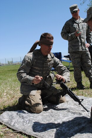 Airman 1st Class Kyle Klusacek, 741st MSFS member, listens to a teammate guide him through the steps of taking apart an M-4 while he is blindfolded, as Tech. Sgt. Travis Jackson, 341st MSFS member, times them.. (U.S. Air Force photo/Airman 1st Class Katrina Heikkinen)
