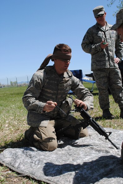 Airman 1st Class Kyle Klusacek, 741st MSFS member, listens to a teammate guide him through the steps of taking apart an M-4 while he is blindfolded, as Tech. Sgt. Travis Jackson, 341st MSFS member, times them.. (U.S. Air Force photo/Airman 1st Class Katrina Heikkinen)