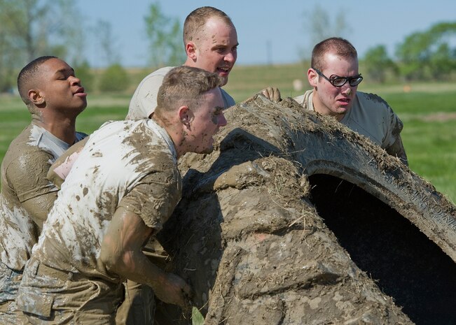 Team 46 flips a tire before jumping back into the mud pit at the team pain station during the competition. From left are 2nd Lt. Michael Bruton, 341st Security Forces Squadron member; Airman 1st Class Antwon Powell, 341st SFS member; Airman 1st Class Brett Johnson, 341st SFS member; and Aimran 1st Class Derek Marris, 341st SFS member. (U.S. Air Force photo/Beau Wade)