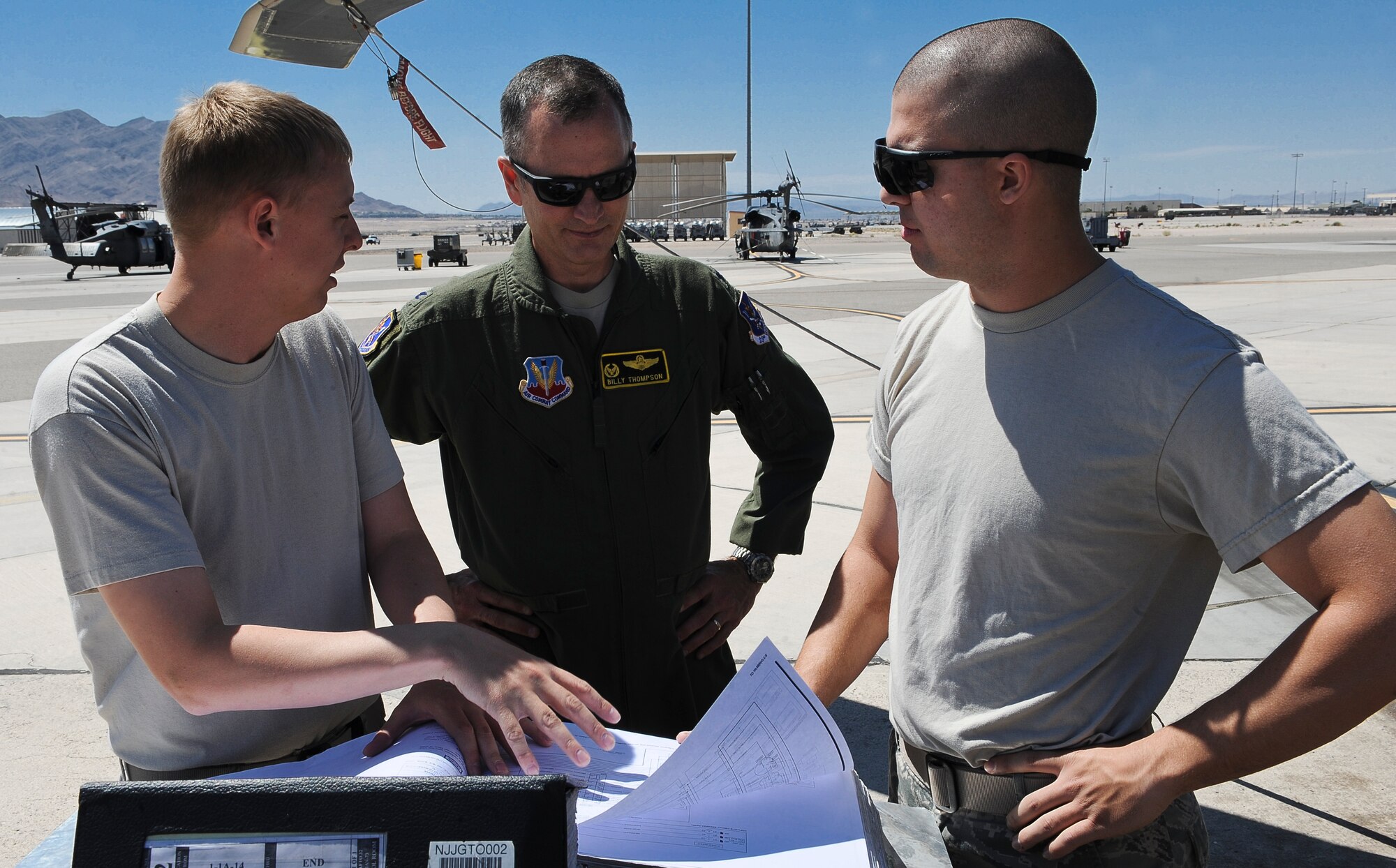 U.S. Air Force Staff Sgt. James Mathis(left) and Airman 1st Class Steven Dores(right), 823d Maintenance Squadron electronic environmental specialists, show Col. Billy Thompson, 23d Wing commander, a technical order at Nellis Air Force Base, Nev., May 7, 2012.  Thompson visited geographically separated units at Nellis to reconnect with Airmen assigned there. (U.S. Air Force photo by Staff Sgt. Ciara Wymbs/Released) 