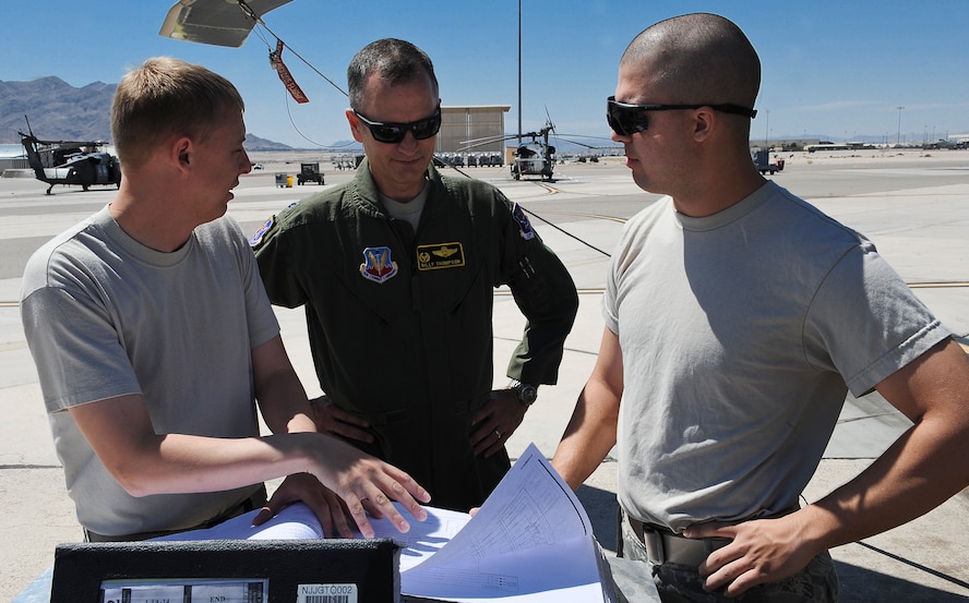 U.S. Air Force Staff Sgt. James Mathis(left) and Airman 1st Class Steven Dores(right), 823d Maintenance Squadron electronic environmental specialists, show Col. Billy Thompson, 23d Wing commander, a technical order at Nellis Air Force Base, Nev., May 7, 2012.  Thompson visited geographically separated units at Nellis to reconnect with Airmen assigned there. (U.S. Air Force photo by Staff Sgt. Ciara Wymbs/Released) 
