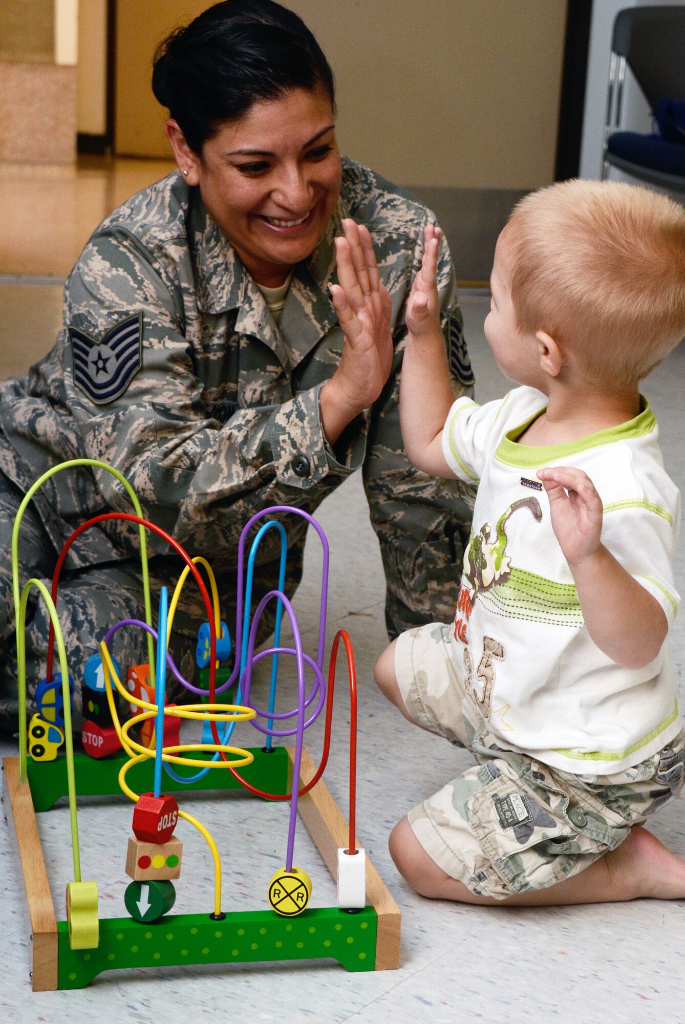 Tech. Sgt. Claudia G. Carrillo Odom, from 80th Aerial Port Squadron entertains a young family member awaiting his Dad's arrival from post deployment in-processing May 17. (U.S. Air Force photo/Don Peek)