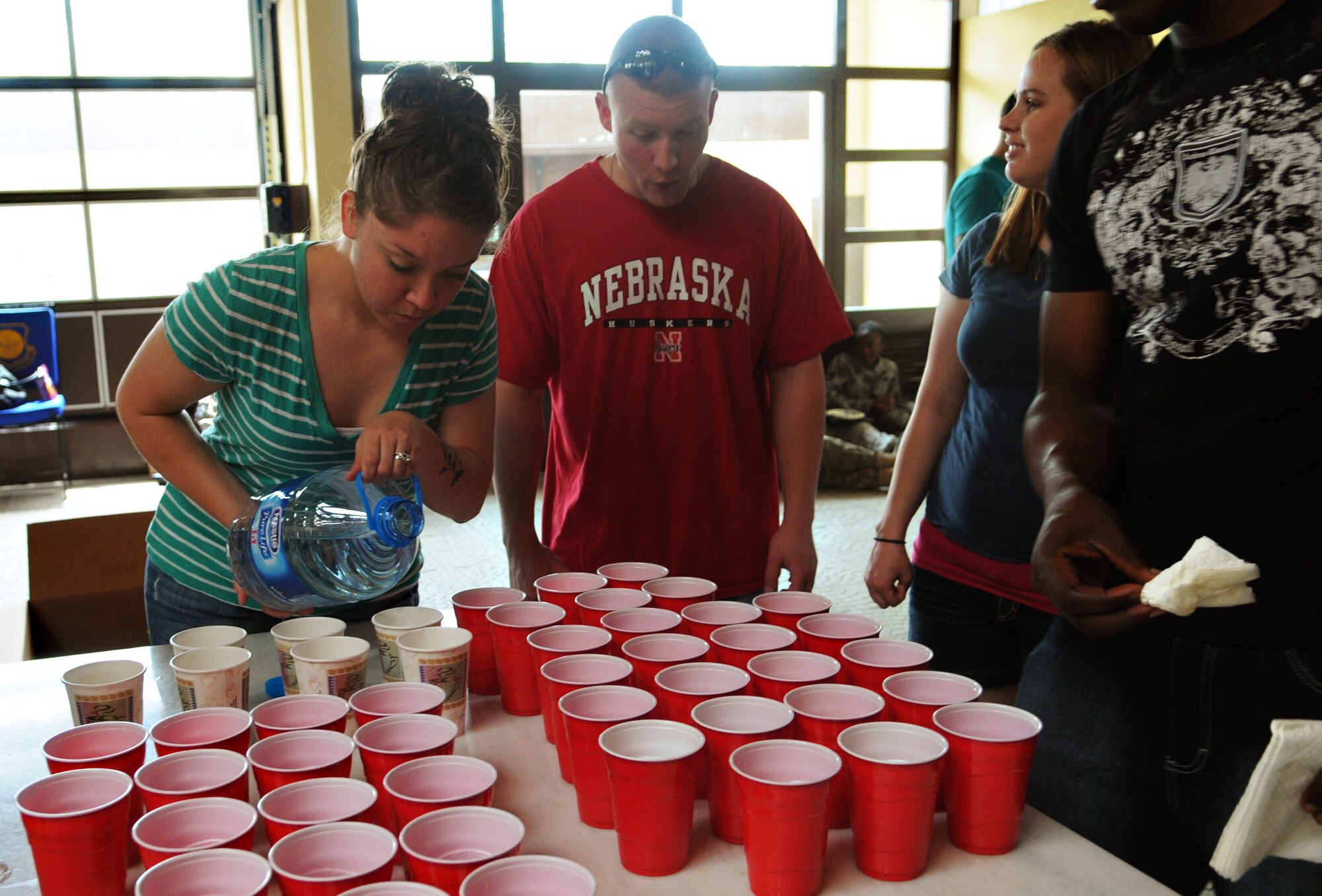 Senior Airman Erin Kirk, Airman leadership School Class 12-D graduate, fills cups with water for redeploying service members on a layover May 12, 2012, as part of Operation First Stop at Incirlik Air Base, Turkey. Operation First Stop is a community service initiative created to welcome redeploying service members who transit through Incirlik on their way back to the U.S. (U.S. Air Force photo by Senior Airman Marissa Tucker/Released)
