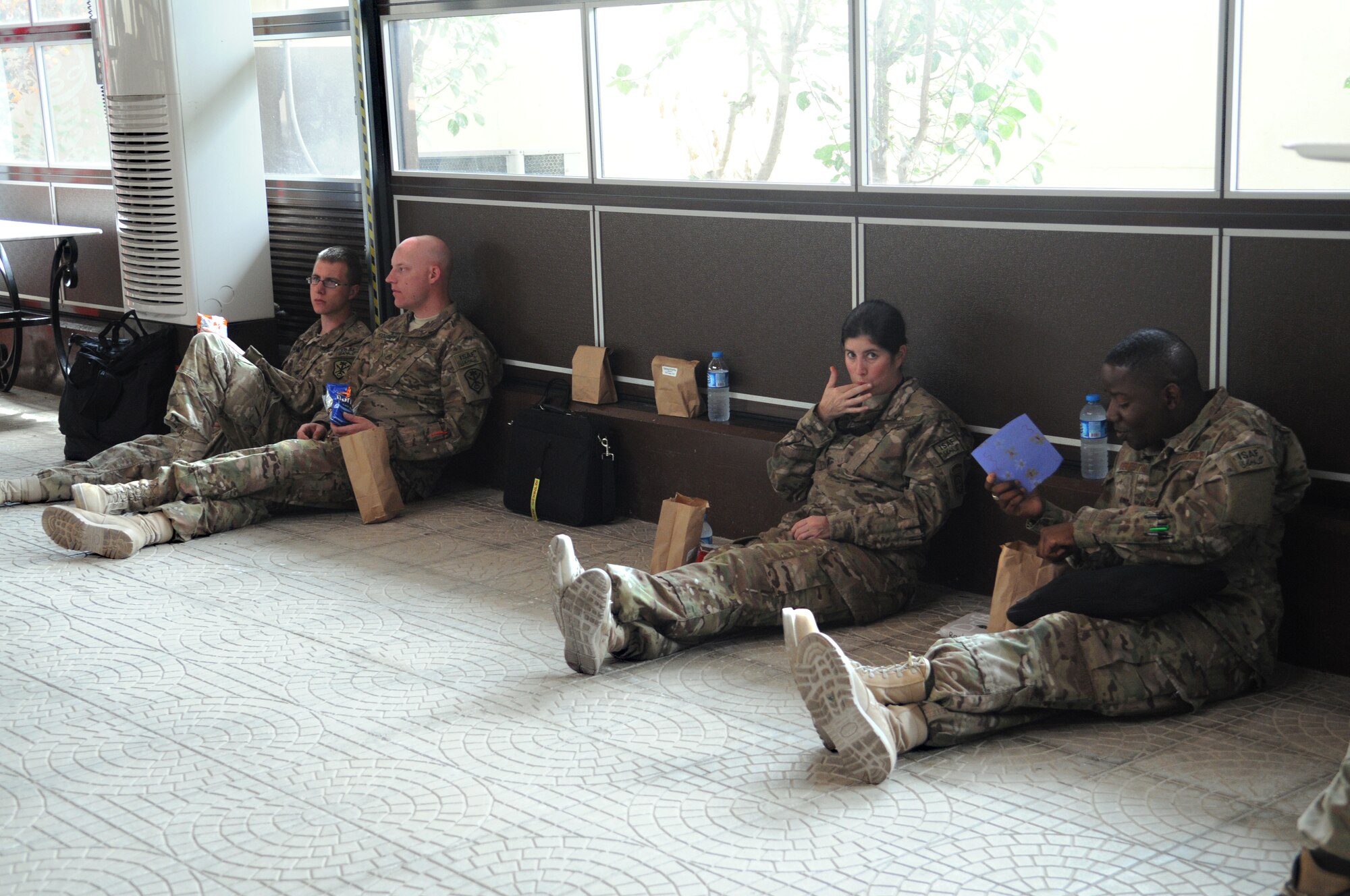 Service members relax and enjoy snacks while on a layover at the Incirlik passenger terminal May 12, 2012 at Incirlik Air Base, Turkey. Food and drinks were provided to redeploying service members by Incirlik Airman Leadership School Class 12-D as part of Operation First Stop, a community service project designed to welcome service members traveling through Incirlik after deployments. (U.S. Air Force photo by Senior Airman Marissa Tucker/Released) 
