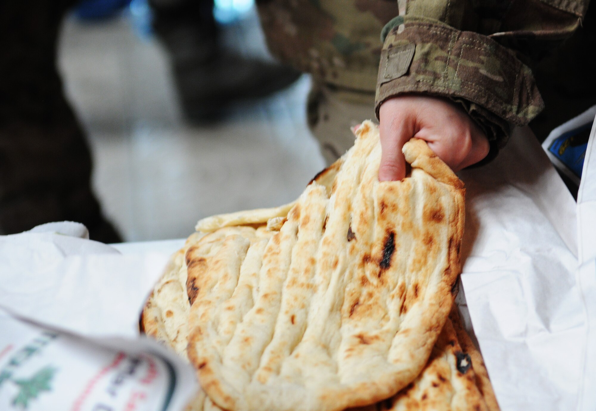 A Soldier grabs a piece of Turkish bread while going through the line at the Incirlik passenger terminal May 12, 2012, at Incirlik Air Base, Turkey. Food and drinks were provided to redeploying service members by Incirlik Airman Leadership School Class 12-D as part of Operation First Stop, a community service project designed to welcome service members traveling through Incirlik after deployments. (U.S. Air Force photo by Senior Airman Marissa Tucker/Released) 