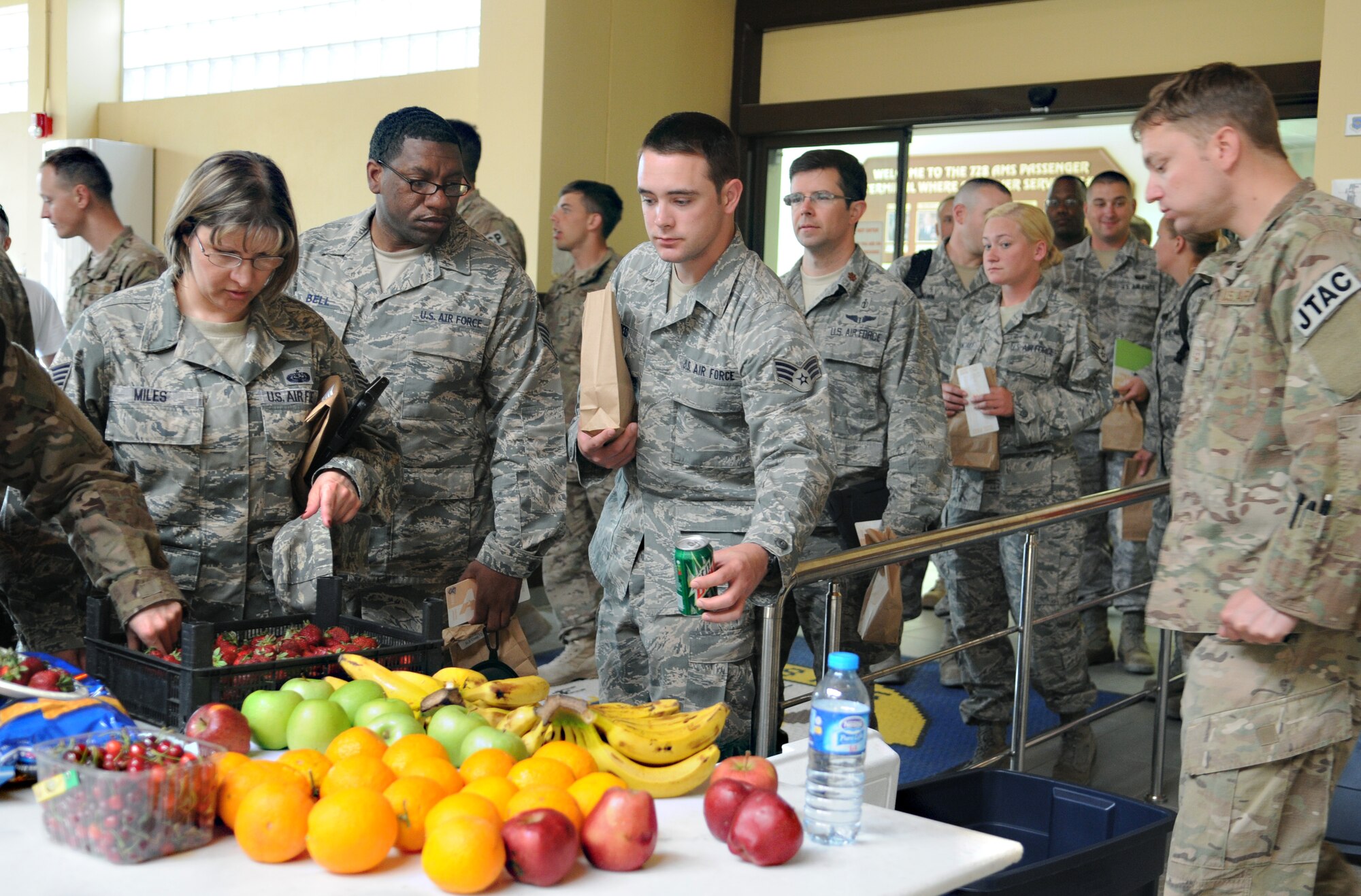 Service members returning from deployments on a layover at the Incirlik passenger terminal wait in line for fruit provided by Operation First Stop May 12, 2012 at Incirlik Air Base, Turkey. Operation First Stop is a community service project created by Incirlik Airman Leadership Class 12-D to provide snacks and drinks to redeploying service members traveling though Incirlik. (U.S. Air Force photo by Senior Airman Marissa Tucker/Released)

 