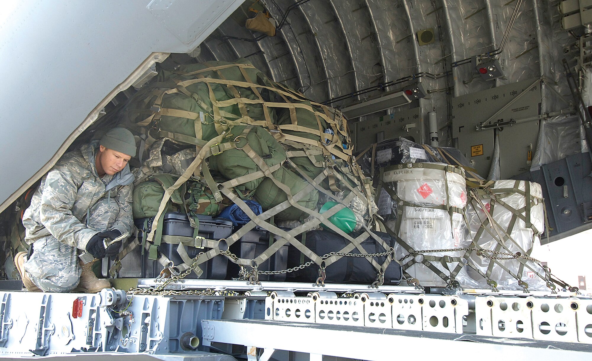 Tech. Sgt. Matthew Armstrong, 72nd Logistics Readiness Squadron, secures pallets in a C-17 aircraft as organizations at Tinker hurry to send relief to Haiti after the 2010 7.0 magnitude earthquake. (Air Force photo by Margo Wright)