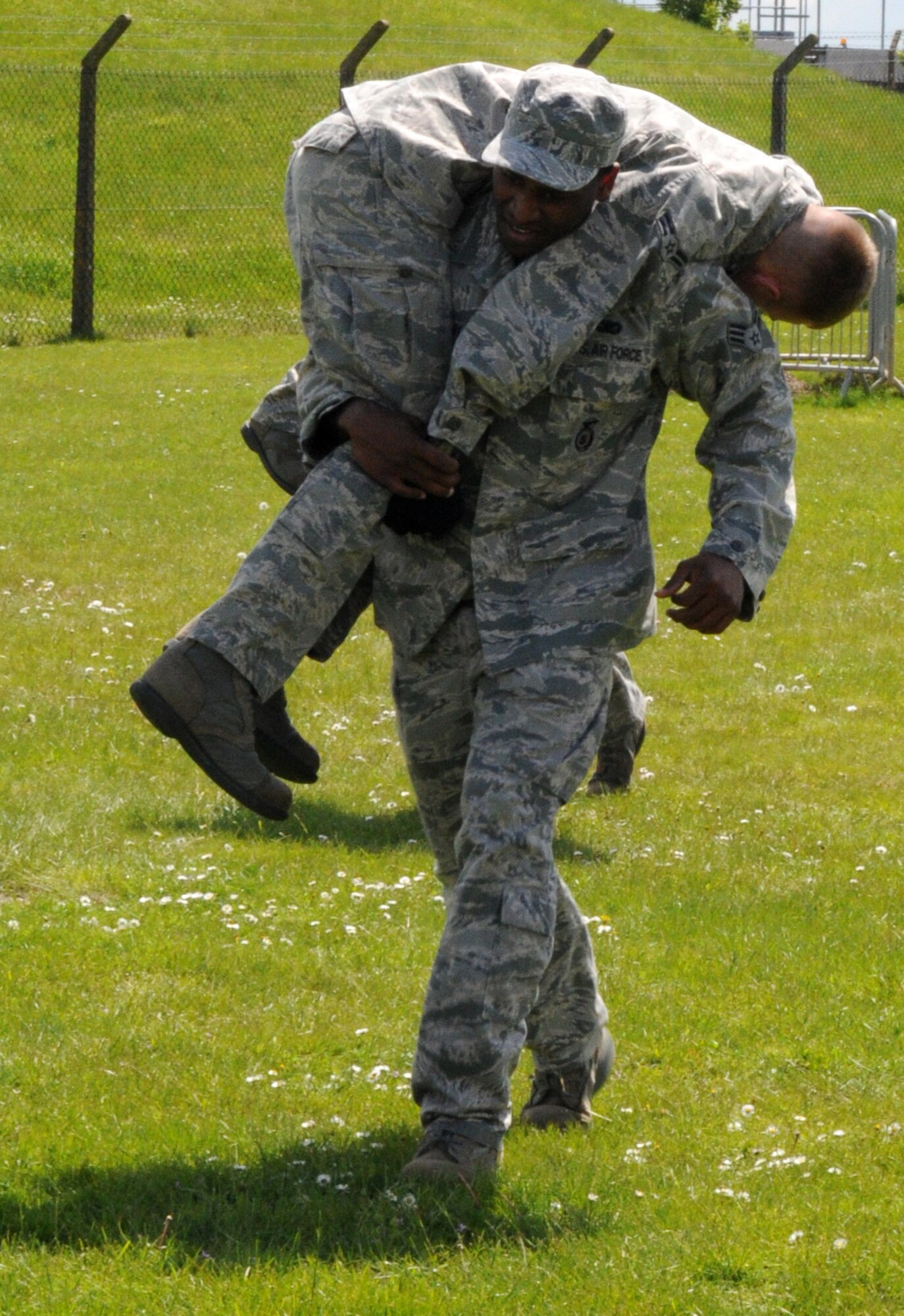 RAF MILDENHALL, England – Senior Airman Adam Leday, 100th Security Forces Squadron, buddy-carries his teammate as part of the “Team Pain” station of the Defender Challenge, May 16, 2012, here. In addition to performing a buddy carry, Airmen had to hoist a 200-pound log across a field and perform five team push-ups. (U.S. Air Force photo/Senior Airman Rachel Waller)