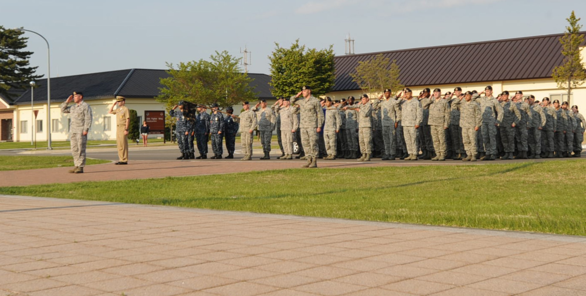 Members of the 35th Security Forces Squadron and Naval Air Facility Misawa Security Detachment, salutes the flag during the National Police Week retreat ceremony at Misawa Air Base, Japan, May 18, 2012. National Police Week is designated to honor fallen police officers. (U.S. Air Force photo by Airman Kenna Jackson/Released)