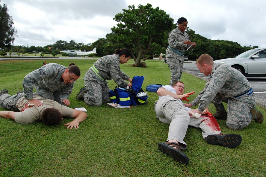 Members from the 18th Wing Judge Advocate office provide self-aid and buddy care to injured member during a local operational readiness exercise scenario on Kadena Air Base, Japan, May 15, 2012. LOREs are conducted on a regular basis to test the base's ability to operate in combat conditions. (U.S. Air Force photo/Senior Master Sgt. Daniel Kazumura)