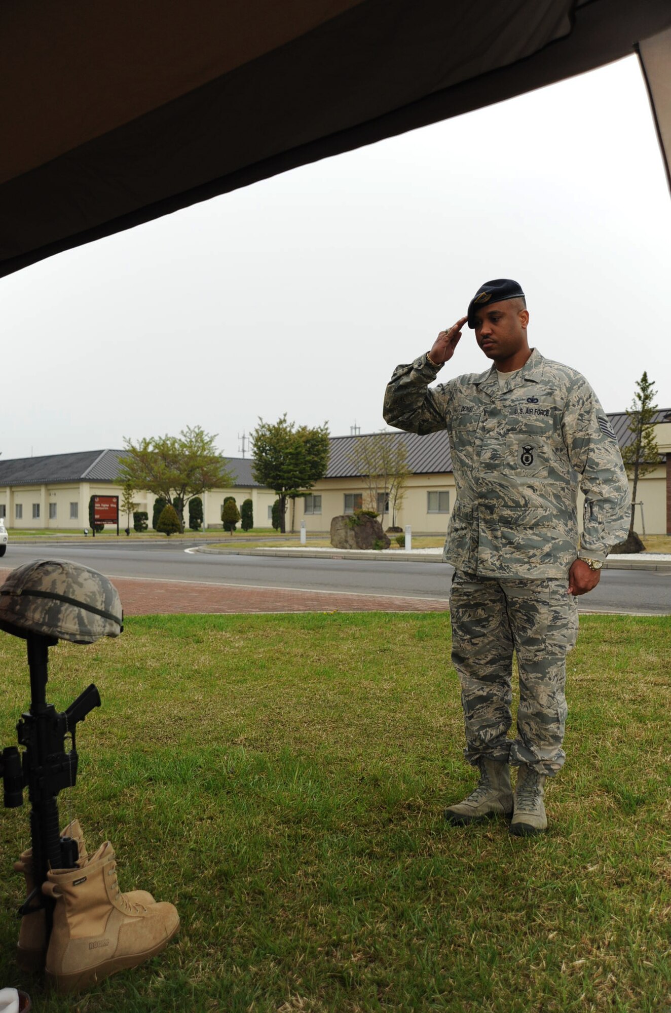 U.S. Air Force Tech. Sgt. Jean-Joseph Denis, 35th Security Forces Squadron confinement administrator, salutes to the memory of fallen police officers during a candlelight vigil in support of National Police Week at Misawa Air Base, Japan, May 15, 2012. In 1962, President John F. Kennedy signed a proclamation which designated May 15th as Peace Officers Memorial Day and the week in which the date fell on as National Police Week. (U.S. Air Force photo by Airman Kenna Jackson)