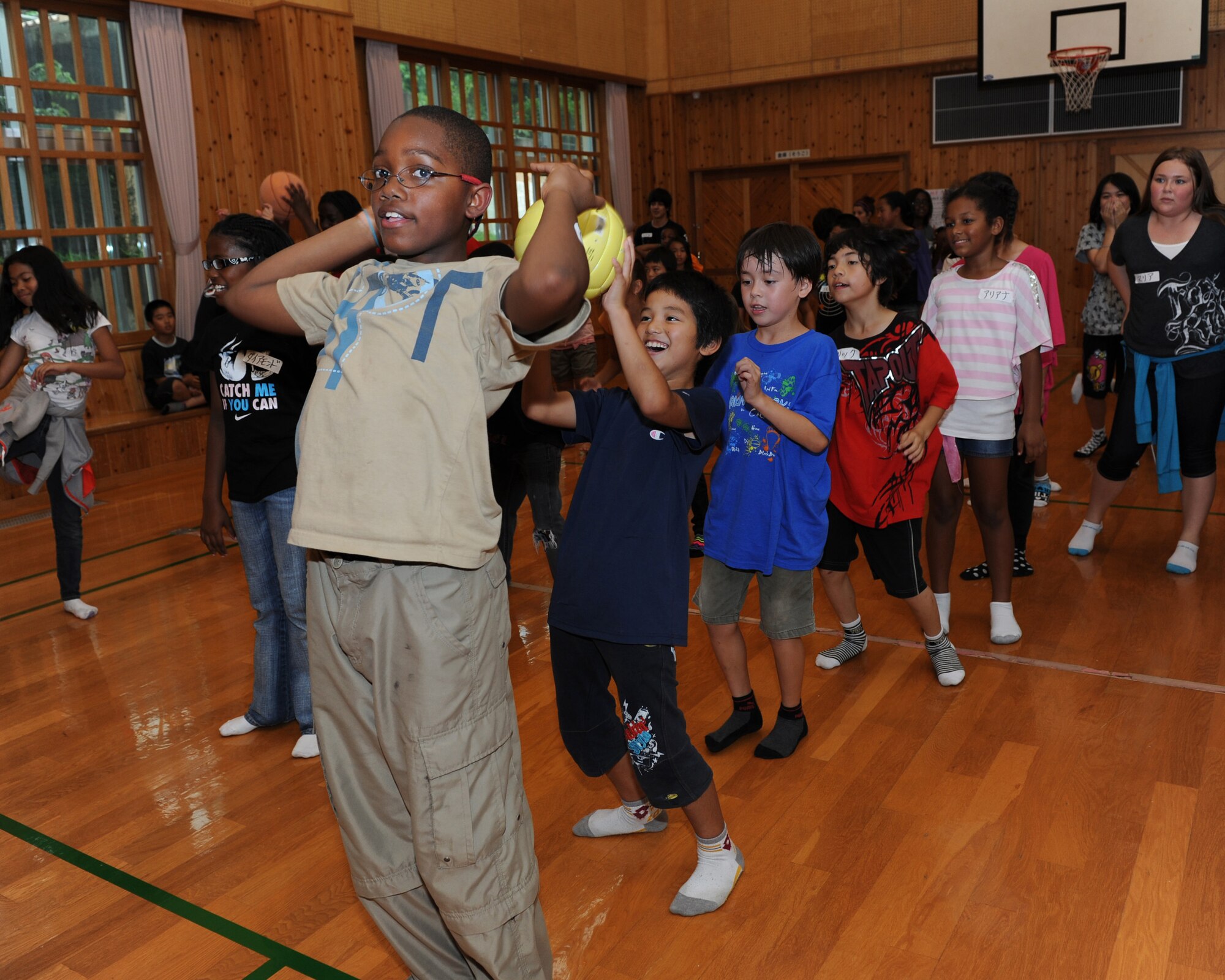 Issac Steed from Kadena's School Age Program passes the ball to Ryoga Zakimi from Kitatama Children's Center while playing "over and under" at the First Children's Exchange Program at the Kitatama Children's Center, Chatan, Okinawa, Japan, May 16, 2012.  Children from Kadena and KCC had fun interacting with each other and playing games during the cultural exchange.  (U.S. Air Force photo/Junko Kinjo)