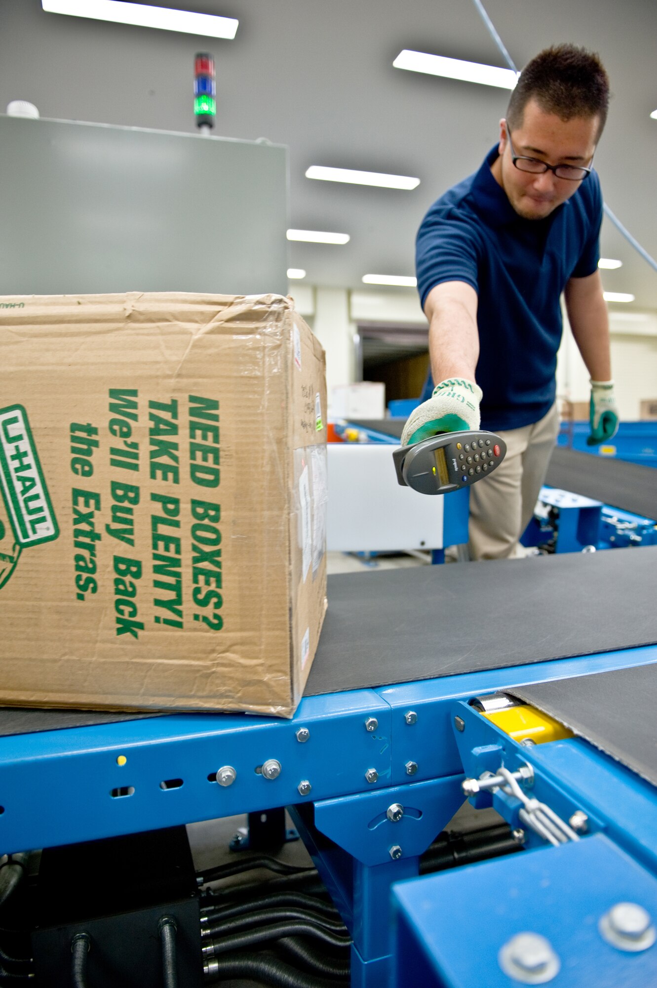 YOKOTA AIR BASE, Japan -- Yazuru Kimura, Detachment 2, Pacific Air Forces Postal Squadron mail sorting supervisor, scans a box at Yokota Air Base, Japan, May 10, 2012. Scanning pieces of mail allows the transit, time and location to be tracked. (U.S. Air Force photo by Airman 1st Class Krystal M. Garrett) 