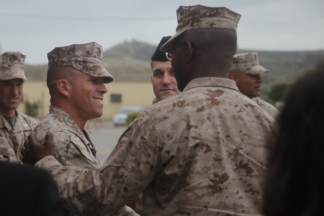 Navy Cross recipient Cpl. Christopher B. Farias is congratulated by Maj. Gen. Ronald L. Bailey, commanding general of 1st Marine Division, after an award ceremony here, May 18. Farias received the nation's second highest award for bravery for actions in Kajaki district, Afghanistan. On Oct. 5, 2010, Farias and his squad were struck by a 73-millimeter recoilless rifle and received fire from three enemy positions during a night ambush. Farias received a concussion and was wounded by shrapnel but exposed himself on a rooftop to direct suppressive fire, allowing casualties to be evacuated. Farias remained in the fight until an airstrike ended the engagement. After the firefight, Farias walked while bleeding more than 2,000 meters to a pickup point.
